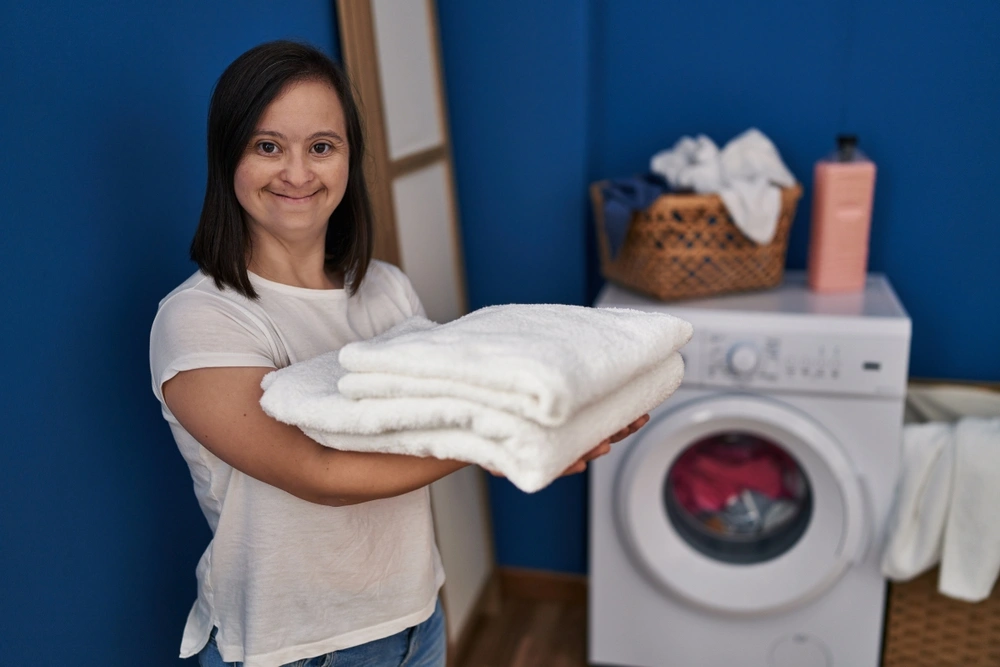 A woman with down syndrome washing clothes