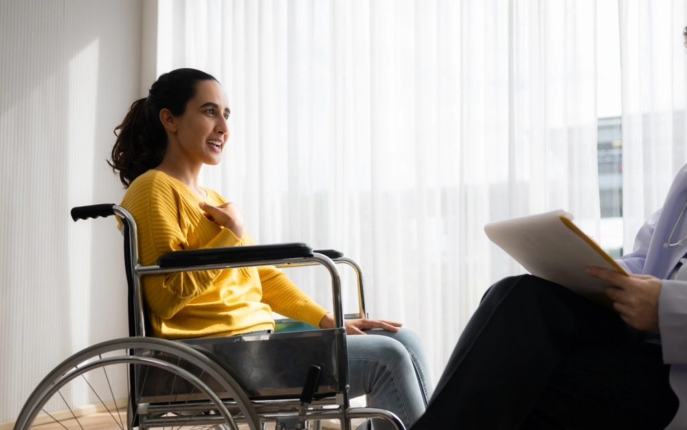 Psychologist counselling a disabled girl on wheel chair