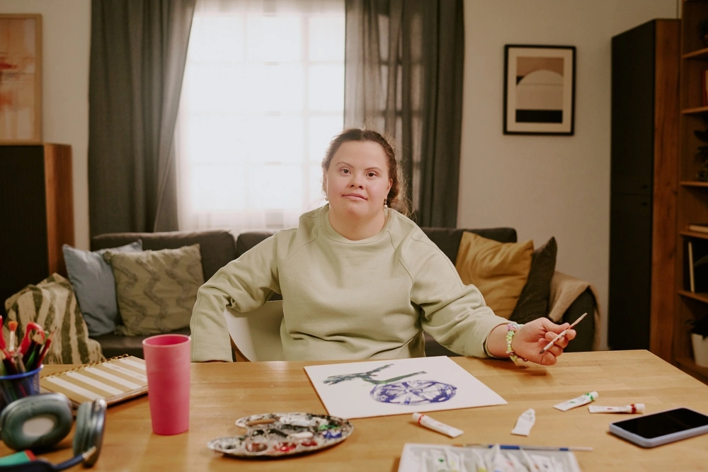 a down syndrome girl is drawing a painting